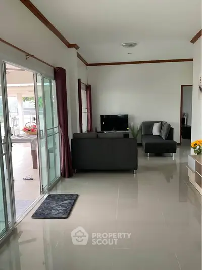 Spacious living room with modern furniture and large sliding glass doors leading to a patio.