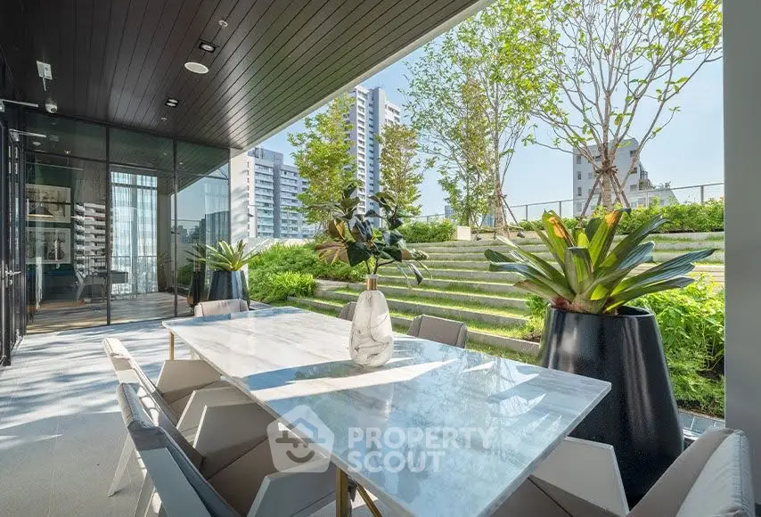 Luxurious outdoor dining area with modern table and lush greenery, perfect for entertaining.