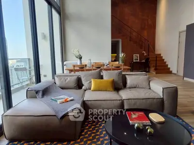 Luxurious modern living room with high ceilings and city view balcony.