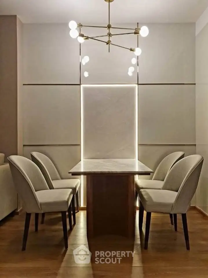 Elegant dining area with modern chandelier and stylish chairs around a sleek table.