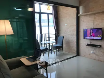 Modern living room with glass partition leading to a cozy balcony with city view.