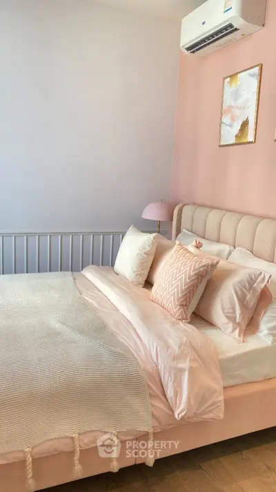 Charming bedroom with pastel decor and cozy ambiance, featuring a plush bed and stylish wall art.