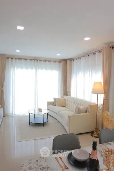 Elegant living room with modern decor and natural light, featuring a plush sofa and stylish coffee table.
