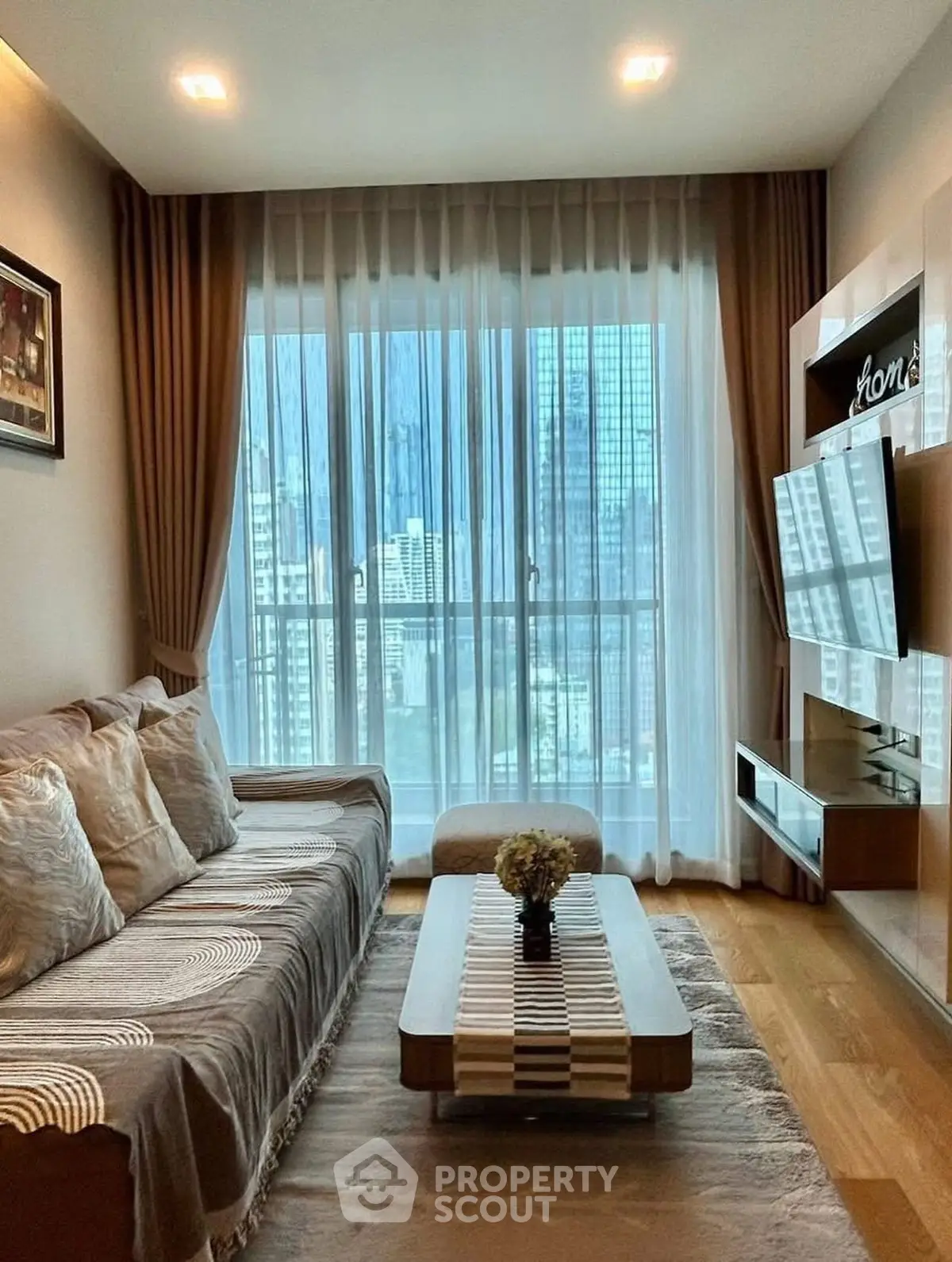 Modern living room with city view, cozy sofa, and stylish decor in high-rise apartment.