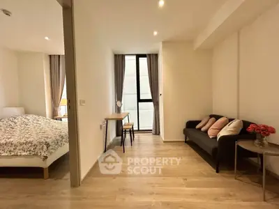 Modern apartment interior with cozy living room and bedroom, featuring wooden flooring and elegant decor.