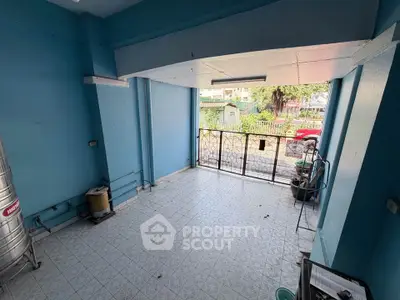 Spacious tiled balcony with blue walls and open view, ideal for relaxation.