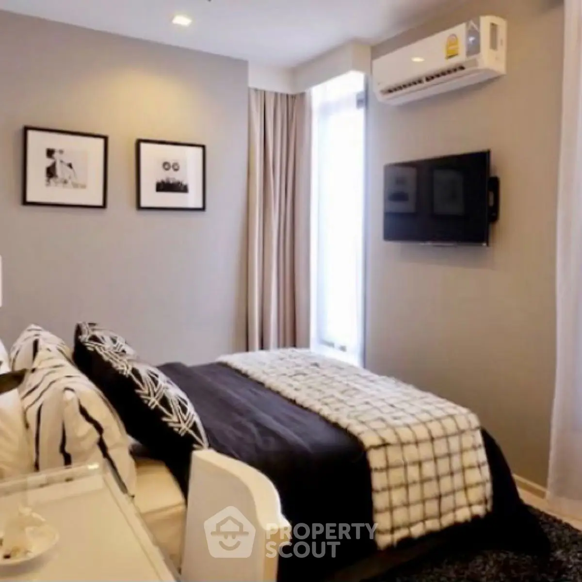 Modern bedroom with stylish decor and wall-mounted TV in a cozy apartment.