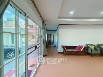Spacious living area with large windows and cozy seating, offering a bright and inviting atmosphere.