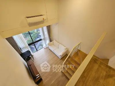 Modern loft apartment with high ceilings and large windows offering a stunning view.