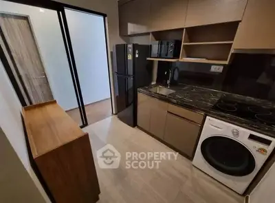 Modern kitchen with sleek appliances and stylish cabinetry in a compact layout.