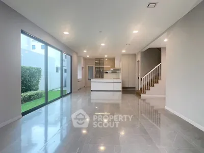 Spacious modern living room with open kitchen and garden view