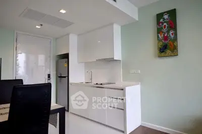 Modern kitchen with sleek white cabinets and integrated appliances in a stylish apartment.