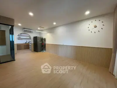 Spacious modern living room with open kitchen layout and stylish wooden flooring.