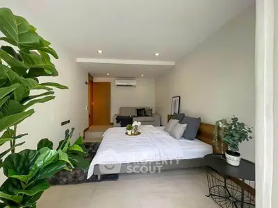 Modern bedroom with cozy decor and natural light, featuring a comfortable bed and stylish furnishings.