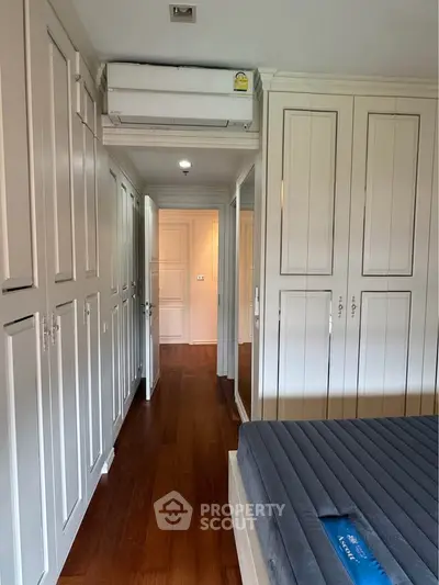 Spacious bedroom with elegant built-in wardrobes and wooden flooring