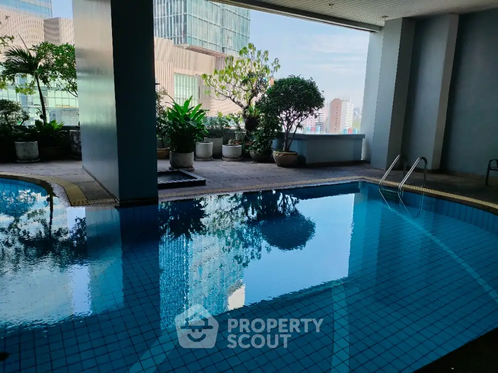 Luxurious indoor pool with city view and lush greenery