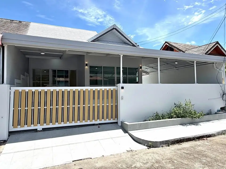Charming single-story home with modern facade and spacious front patio, perfect for family living.