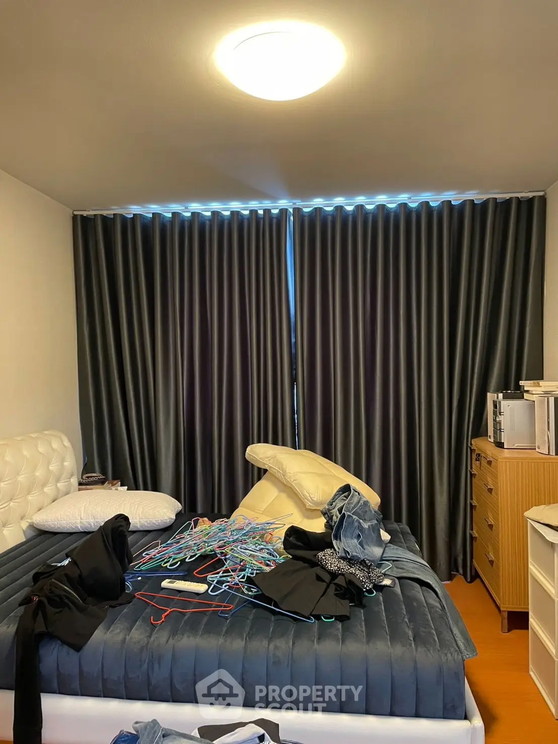 Cozy bedroom with modern decor and ample natural light through large windows.