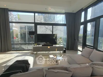 Luxurious living room with floor-to-ceiling windows and modern decor in a high-rise apartment.