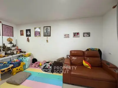 Cozy living room with leather sofa and colorful play area, perfect for family relaxation.