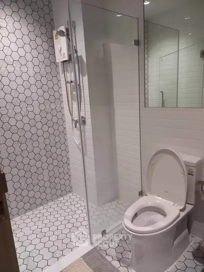 Modern bathroom with stylish geometric tiles and glass shower enclosure