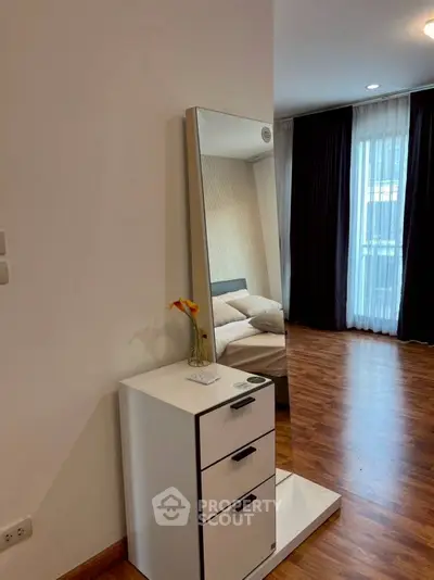 Modern bedroom with wooden flooring and stylish mirror dresser