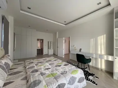 Spacious modern bedroom with stylish decor and ample natural light