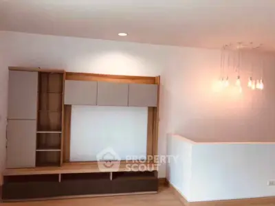 Modern living room with stylish shelving and unique lighting fixture.