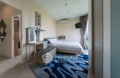 Modern bedroom with stylish decor and city view, featuring a cozy bed and unique carpet design.