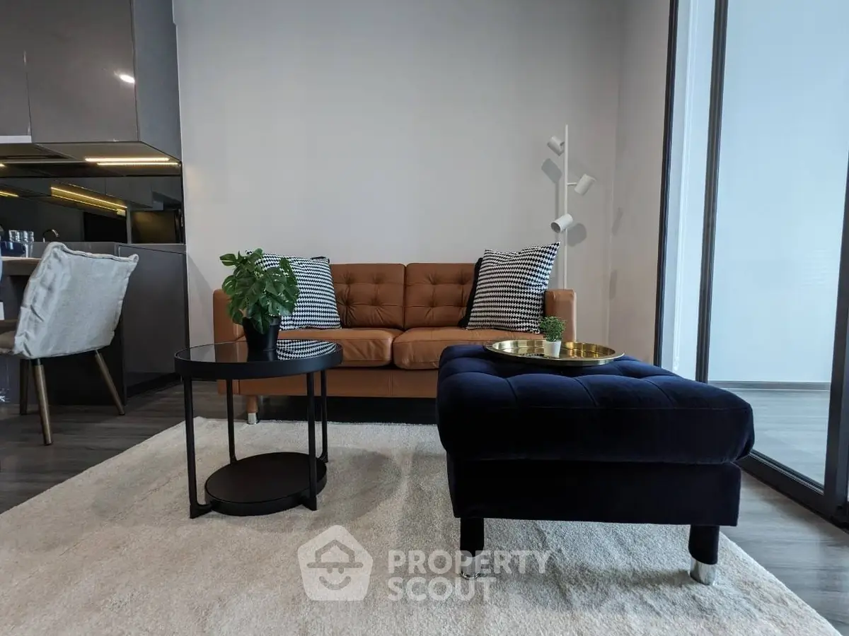Chic modern living room with elegant leather sofa, plush ottoman, and stylish decor, complemented by a cozy area rug and natural light.