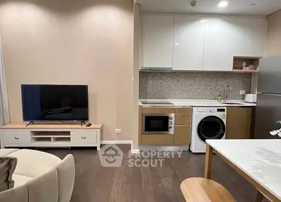 Modern open-plan living room with kitchen featuring sleek appliances and stylish decor.