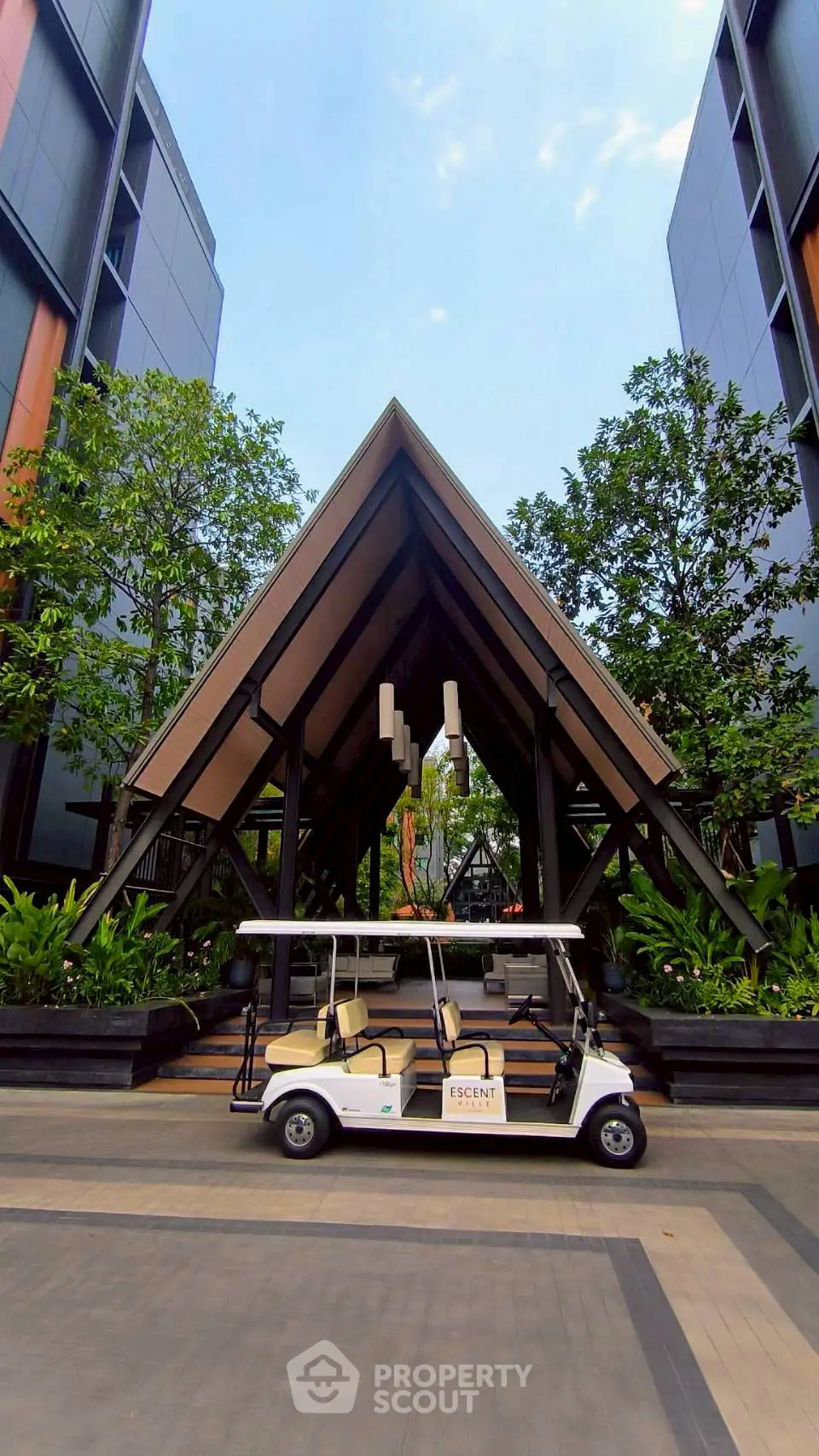 Modern building entrance with unique architectural design and lush greenery