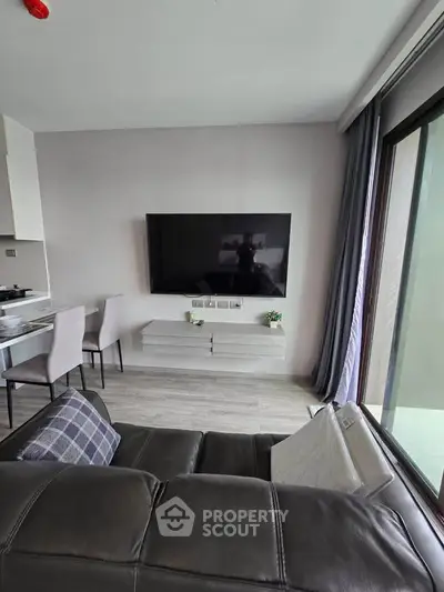 Modern living room with wall-mounted TV and sleek furniture in a stylish apartment.