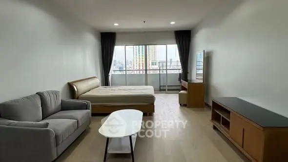 Spacious studio apartment with modern furnishings and city view.