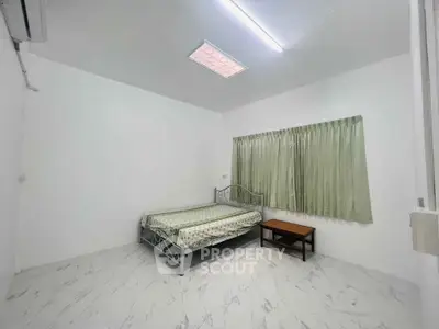 Minimalist bedroom with metal bed frame and marble flooring