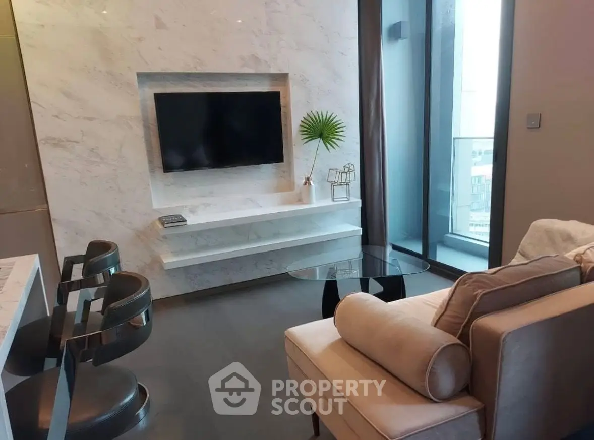 Modern living room with sleek marble wall, flat-screen TV, and stylish furniture in a high-rise apartment.