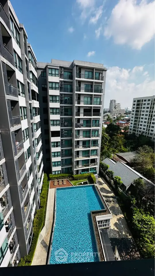 Stunning high-rise building with a luxurious pool and city view, perfect for urban living.