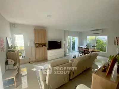 Spacious living room with modern decor and large windows offering natural light.