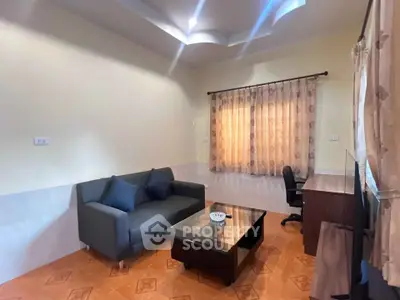 Cozy living room with modern sofa and work desk, perfect for relaxation and productivity.