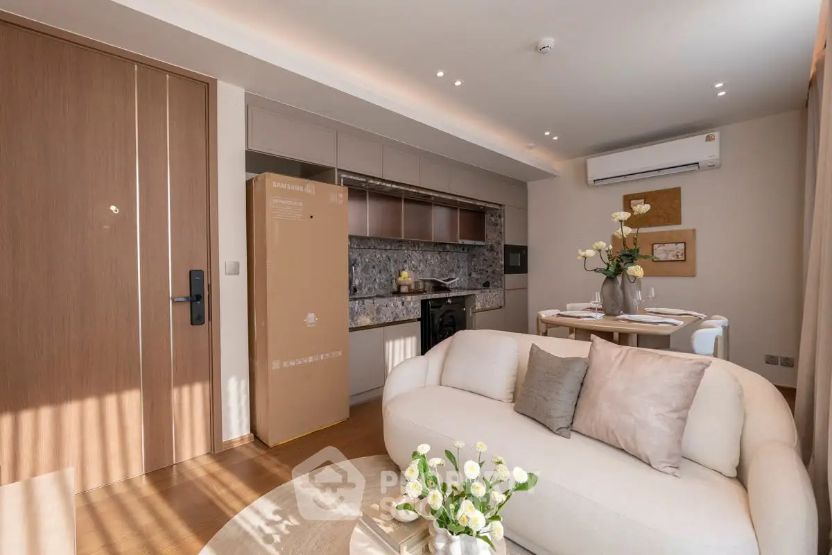 Modern living room with cozy sofa, stylish kitchen, and elegant dining area in a well-lit apartment.