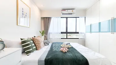 Bright and modern bedroom with large window and stylish decor in a high-rise apartment.