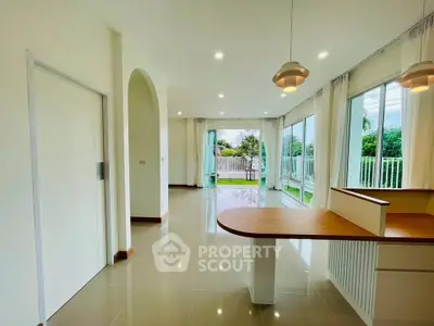 Spacious open-plan living area with large windows and garden view.