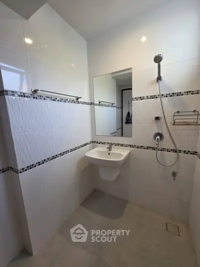 Modern bathroom with sleek white tiles and wall-mounted sink