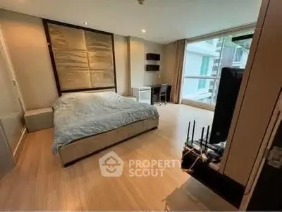 Spacious modern bedroom with large window and stylish decor in a luxury apartment.