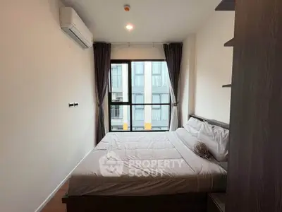 Cozy bedroom with large window and modern air conditioning unit in a stylish apartment.