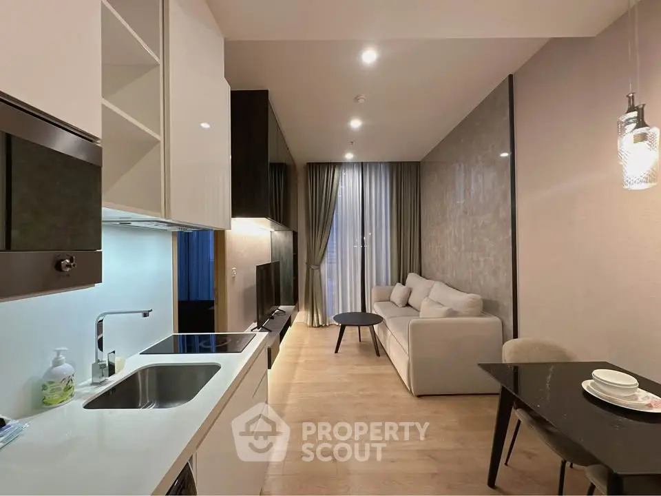 Modern open-plan living room and kitchen with sleek design and cozy ambiance.