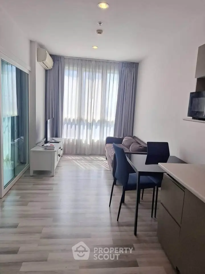 Modern living room with sleek furniture and large windows in a stylish apartment.