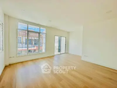 Spacious and bright living room with large windows and wooden flooring