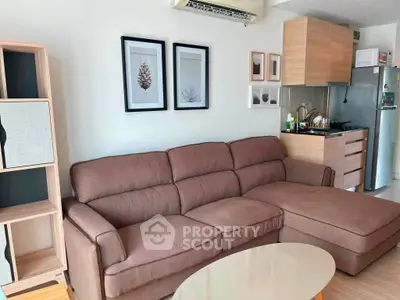 Modern living room with cozy brown sofa and compact kitchen in open layout apartment.