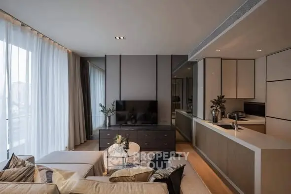 Modern open-layout living room with sleek kitchen, cozy seating, and large windows for natural light.